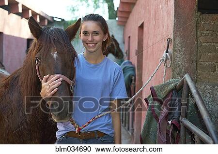 Teenage girl hugging horse at stable on ranch View Large Photo Image Stock Image - Teenage girl hugging horse at stable on ranch. Fotosearch