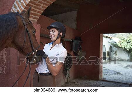 Teenage girl leading horse in stable on ranch View Large Photo Image Stock Photograph - Teenage girl leading horse in stable on ranch. Fotosearch
