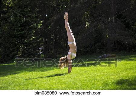 Woman doing handstand in backyard View Large Photo Image Stock Image - Woman doing handstand in backyard. Fotosearch