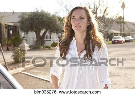 Stock Photograph - Woman standing in parking lot. Fotosearch