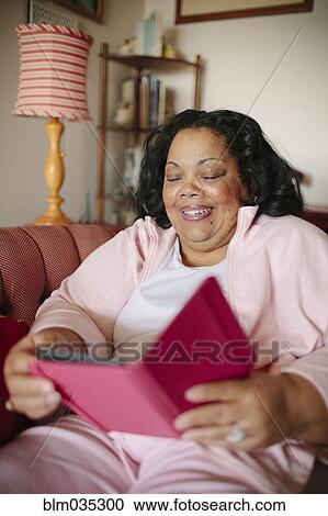 Woman using digital tablet in living room View Large Photo Image Stock Image - Woman using digital tablet in living room. Fotosearch