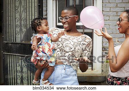 Picture - Women and girl playing with balloon outdoors. Fotosearch