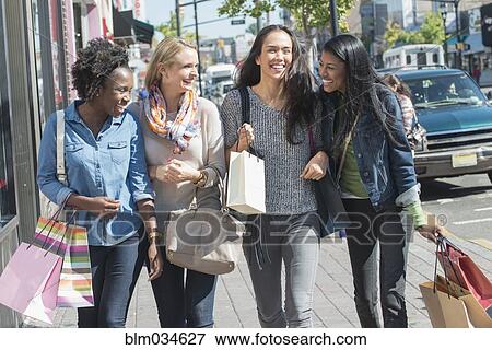 Women carrying shopping bags on city sidewalk View Large Photo Image Stock Photo - Women carrying shopping bags on city sidewalk. Fotosearch