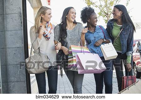 Women carrying shopping bags on city sidewalk View Large Photo Image Stock Photo - Women carrying shopping bags on city sidewalk. Fotosearch