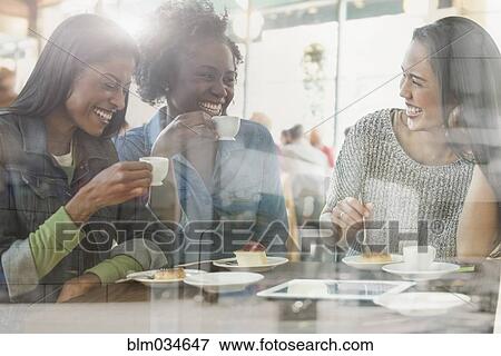 Stock Photo - Women drinking coffee in cafe. Fotosearch