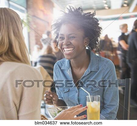 Stock Photo - Women eating food in cafe. Fotosearch