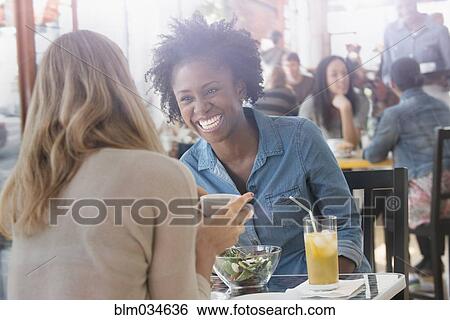 Stock Photograph - Women eating food in cafe. Fotosearch