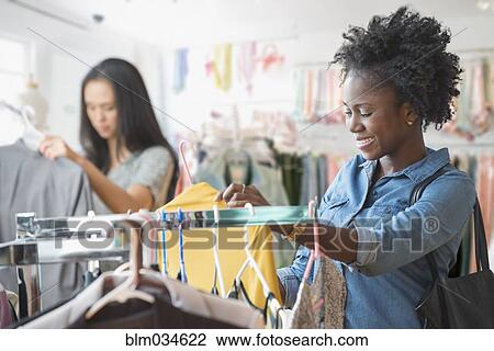 Stock Image - Women shopping in clothing store. Fotosearch