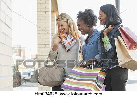 Stock Photo - Women window shopping outside store. Fotosearch