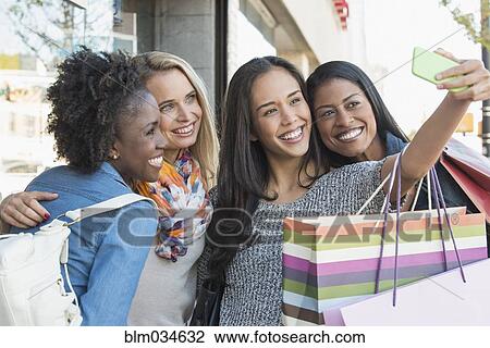 Women with shopping bags taking selfie View Large Photo Image Stock Image - Women with shopping bags taking selfie. Fotosearch