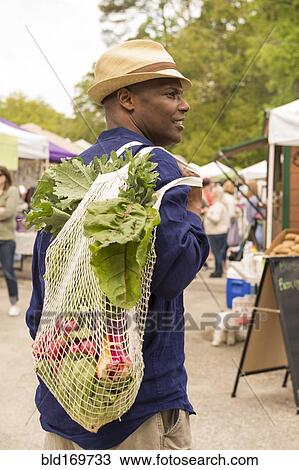African American man carrying bag of produce at market View Large Photo Image Stock Image - African American man carrying bag of produce at market. Fotosearch