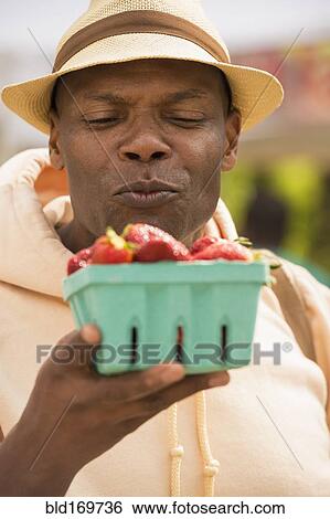 African American man examining basket of strawberries View Large Photo Image Stock Photograph - African American man examining basket of strawberries. Fotosearch