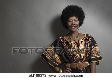 Stock Image - African American woman smiling with hand on hip. Fotosearch