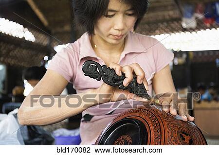 Asian artisan carving traditional design in workshop View Large Photo Image Stock Image - Asian artisan carving traditional design in workshop. Fotosearch