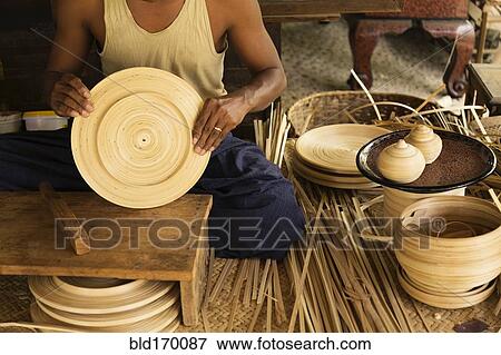 Asian artisan weaving traditional baskets in workshop View Large Photo Image Stock Photo - Asian artisan weaving traditional baskets in workshop. Fotosearch
