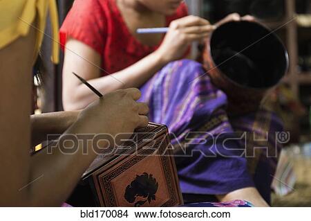 Picture - Asian artisans carving traditional design in workshop. Fotosearch
