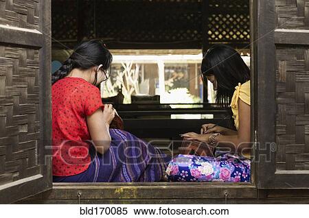 Stock Photography - Asian artisans carving traditional design in workshop. Fotosearch