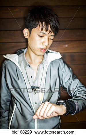 Asian man checking wristwatch View Large Photo Image Stock Photo - Asian man checking wristwatch. Fotosearch