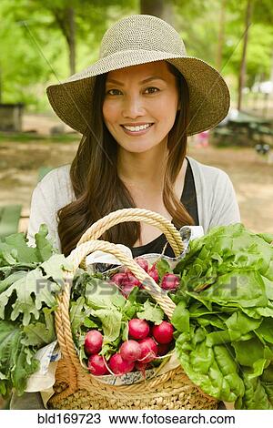 Asian woman carrying basket of produce View Large Photo Image Stock Image - Asian woman carrying basket of produce. Fotosearch