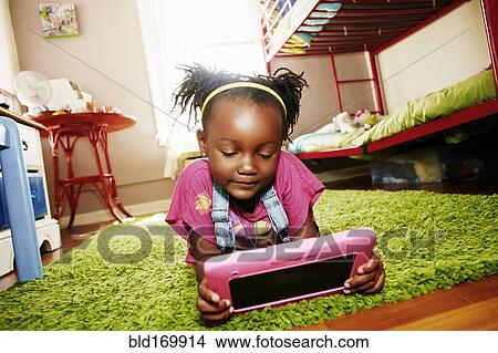 Black girl using digital tablet in bedroom View Large Photo Image Picture - Black girl using digital tablet in bedroom. Fotosearch