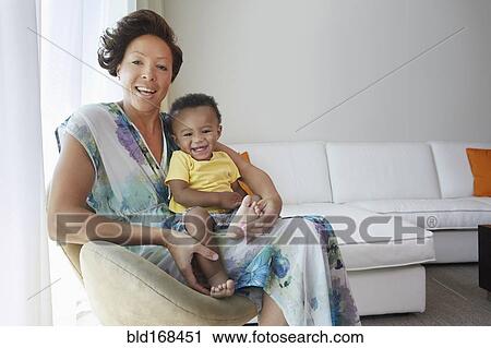 Black mother and son sitting in living room View Large Photo Image Stock Image - Black mother and son sitting in living room. Fotosearch