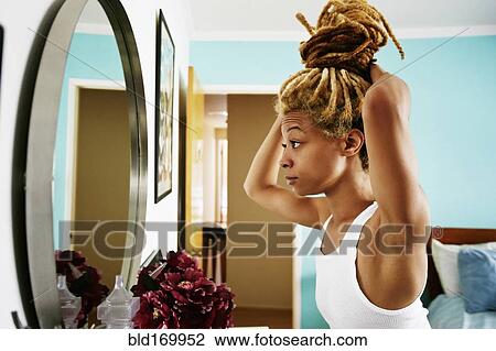 Black woman examining herself in mirror View Large Photo Image Stock Image - Black woman examining herself in mirror. Fotosearch