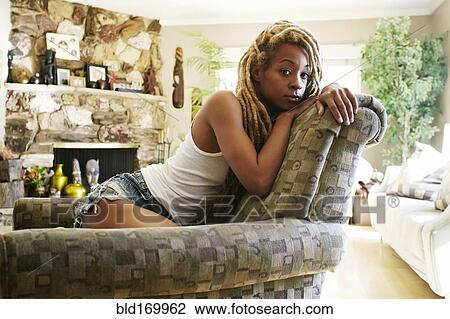 Black woman sitting on armchair in living room View Large Photo Image Stock Image - Black woman sitting on armchair in living room. Fotosearch