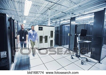 Blurred view of technicians pushing cart in server room View Large Photo Image Picture - Blurred view of technicians pushing cart in server room. Fotosearch