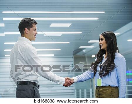 Stock Photo - Business people shaking hands in office. Fotosearch