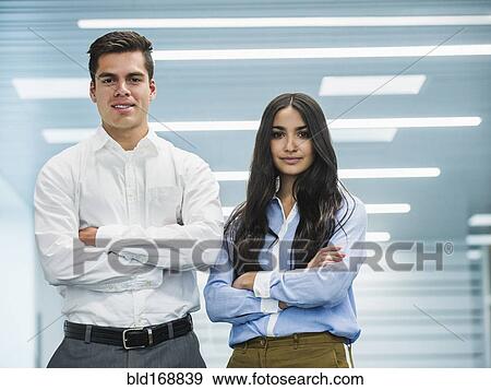 Stock Photo - Business people standing with arms folded in office. Fotosearch