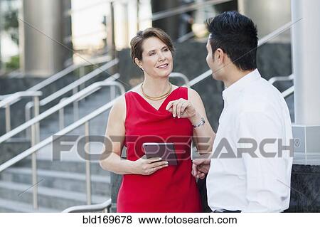 Stock Photo - Business people using digital tablet near staircase. Fotosearch