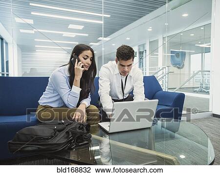 Business people using laptop in office lobby View Large Photo Image Stock Image - Business people using laptop in office lobby. Fotosearch