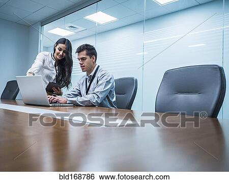 Business people using laptop in conference room View Large Photo Image Stock Photograph - Business people using laptop in conference room. Fotosearch
