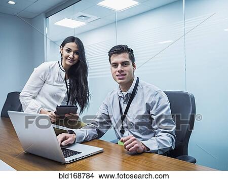 Picture - Business people using technology in conference room. Fotosearch