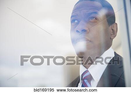 Stock Photography - Businessman looking out office window. Fotosearch