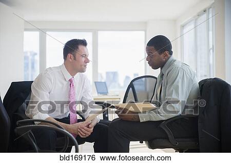Stock Photograph - Businessmen holding folders in office. Fotosearch