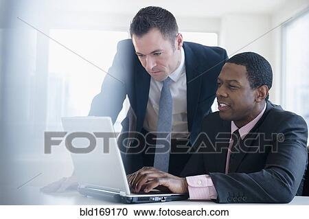 Businessmen using laptop in office View Large Photo Image Stock Image - Businessmen using laptop in office. Fotosearch