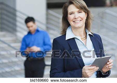 Businesswoman using digital tablet near staircase View Large Photo Image Stock Image - Businesswoman using digital tablet near staircase. Fotosearch