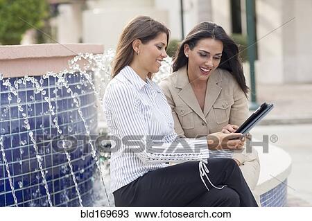 Businesswomen using digital tablet near fountain View Large Photo Image Stock Image - Businesswomen using digital tablet near fountain. Fotosearch