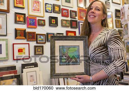 Caucasian artist holding artwork in gallery View Large Photo Image Stock Image - Caucasian artist holding artwork in gallery. Fotosearch