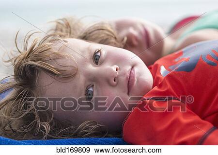 Stock Photo - Caucasian baby boy laying on beach. Fotosearch