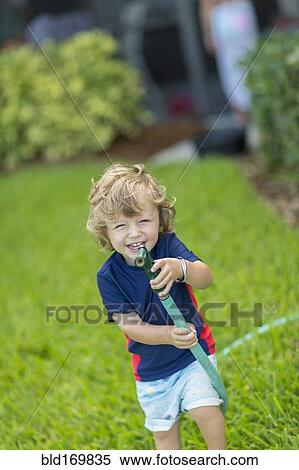 Caucasian baby boy playing with hose in backyard View Large Photo Image Stock Photography - Caucasian baby boy playing with hose in backyard. Fotosearch
