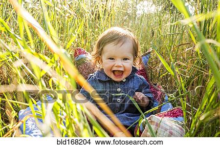 Caucasian baby girl sitting in tall grass View Large Photo Image Picture - Caucasian baby girl sitting in tall grass. Fotosearch
