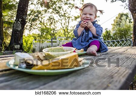 Caucasian baby girl sitting on patio table View Large Photo Image Stock Photograph - Caucasian baby girl sitting on patio table. Fotosearch