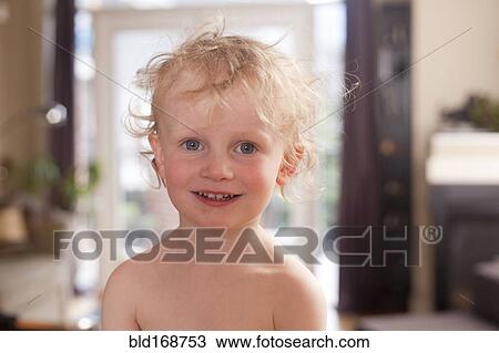 Stock Image - Caucasian boy smiling in living room. Fotosearch