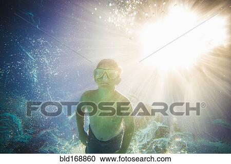 Caucasian boy swimming underwater in swimming pool View Large Photo Image Stock Image - Caucasian boy swimming underwater in swimming pool. Fotosearch