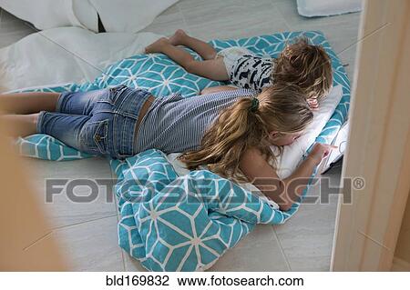 Caucasian brother and sister using digital tablet on bed View Large Photo Image Stock Image - Caucasian brother and sister using digital tablet on bed. Fotosearch