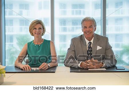 Stock Image - Caucasian business people smiling in meeting. Fotosearch