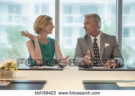 Stock Image - Caucasian business people talking in meeting. Fotosearch