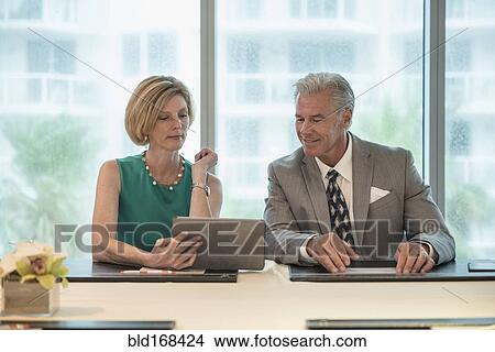 Caucasian business people using digital tablet in meeting View Large Photo Image Picture - Caucasian business people using digital tablet in meeting. Fotosearch